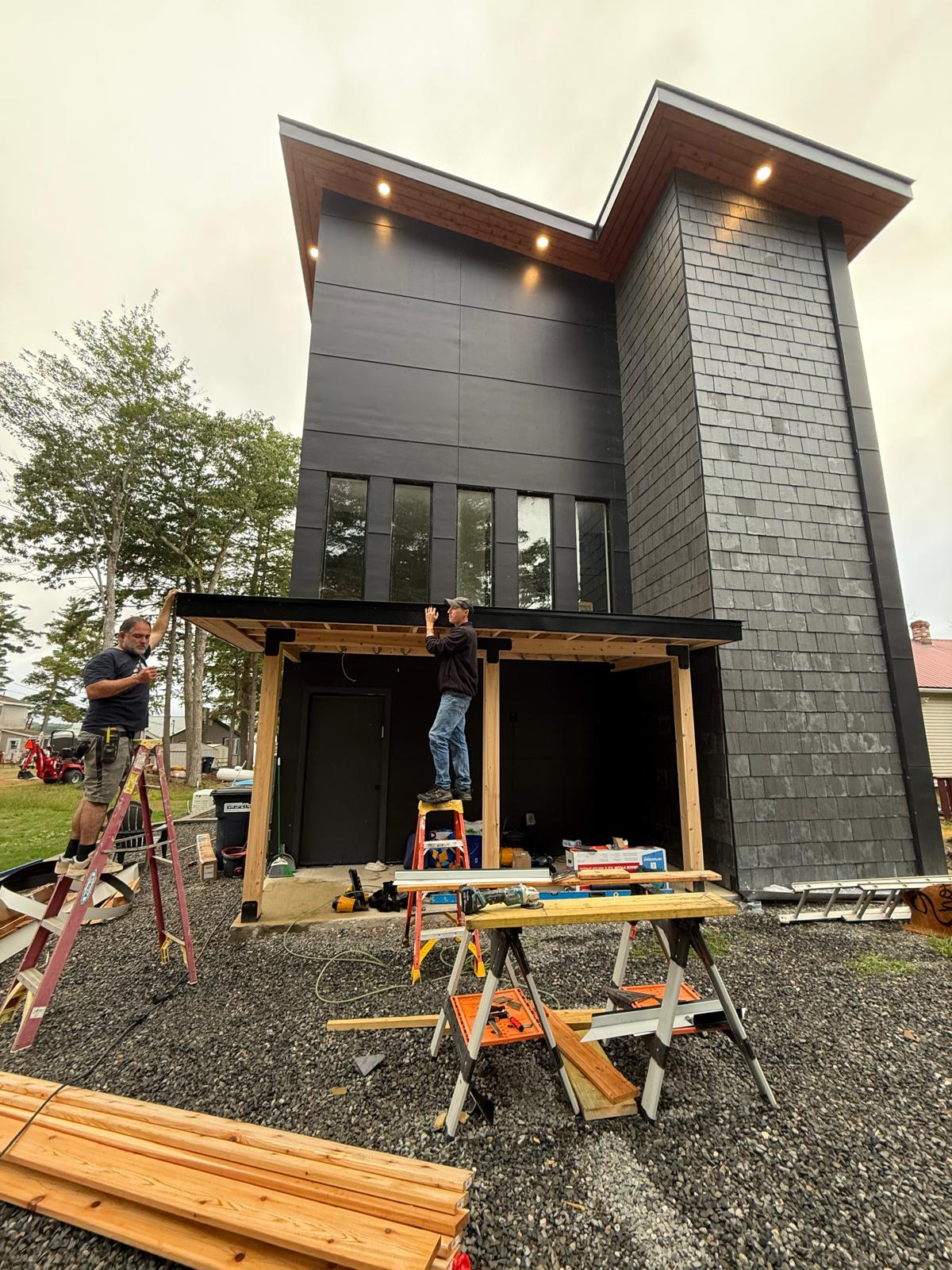 Modern black-clad home with cedar-shingle tower